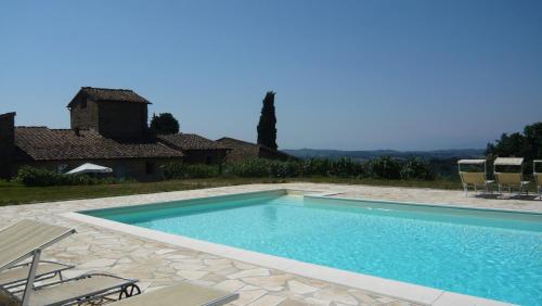 a swimming pool in front of a house at Mezzano In Chianti in Strada