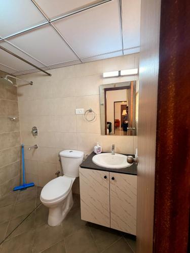 a bathroom with a toilet and a sink at Bay Breeze 2BR Apt Amoret Homes in Chicalim