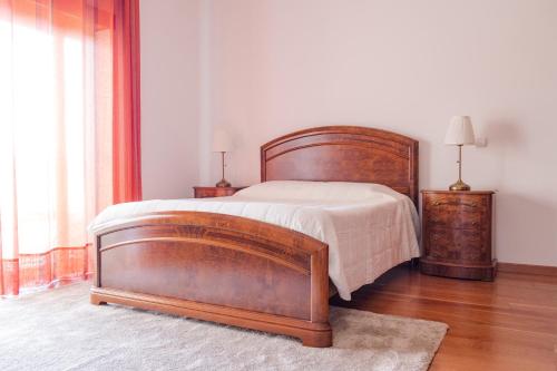 a bedroom with a large wooden bed and two lamps at Quinta Vale do Armo in Sardoal