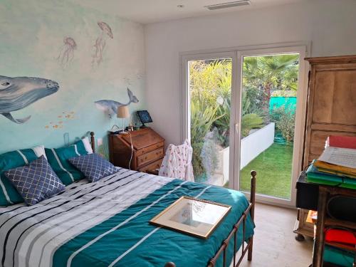 a bedroom with a bed with a fish mural on the wall at La Petite Bergerie in Fréjus