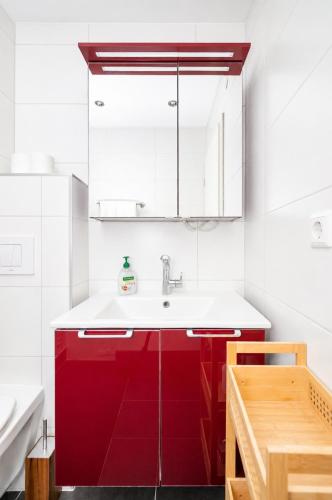a bathroom with red cabinets and a sink at 2 bedroom flat Bonnevoie - sleeps 7 in Luxembourg