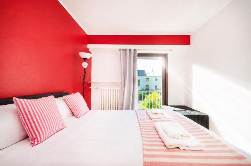 a red bedroom with a bed with two towels on it at 2 bedroom flat Bonnevoie - sleeps 7 in Luxembourg