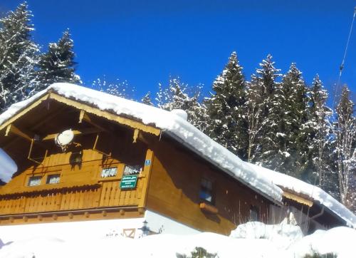 a log cabin with snow on the roof at Gästehaus Kurz in Berchtesgaden