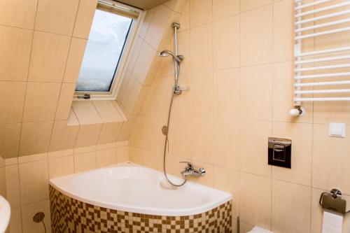 a bath tub in a bathroom with a window at Zacisza Tetmajera in Zakopane