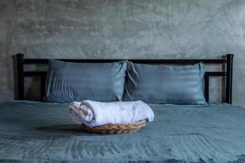 a basket with a towel sitting on a bed at Sun Resort in Sa Kaeo