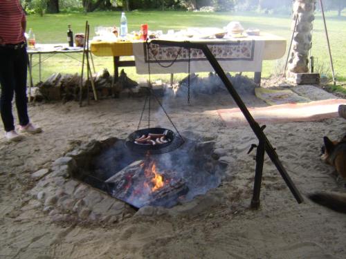 a fire pit with a grill and a table at Anglo-Polish Holidays in Chycina