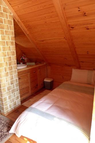 a bedroom with a bed in a wooden cabin at Anglo-Polish Holidays in Chycina