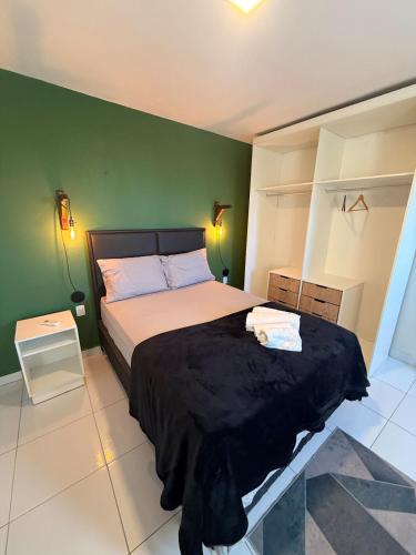 a bedroom with a bed and a green wall at Loft Luiz Gonzaga in Campina Grande
