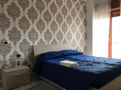 Un dormitorio con una cama azul y una pared en Supera Napoli Apartment, en Nápoles