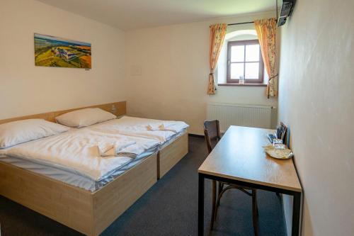 a bedroom with a bed and a table in it at Hospoda na sýpce in Kuks