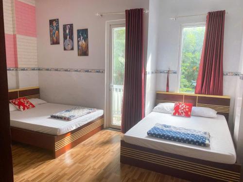 two beds in a room with two windows at MyDungmotel in Danang