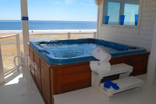a bath tub with a view of the beach at Blue - Inn on the Beach in Newburyport