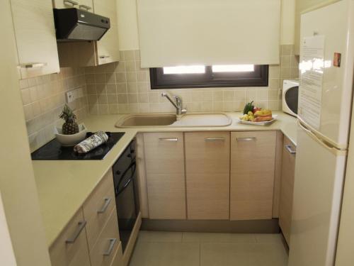 a small kitchen with a sink and a refrigerator at Kyklades Resort & Spa in Paralimni