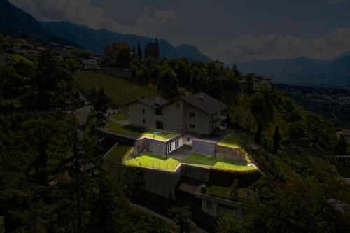 a house on a hill with lights on it at Residence Fiegl in Schenna