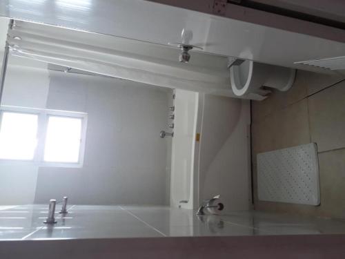 a white kitchen with a sink and a window at Andres Resort in Nabas