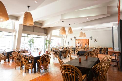 a dining room with tables and chairs and windows at Bonito Hotel in San Rafael