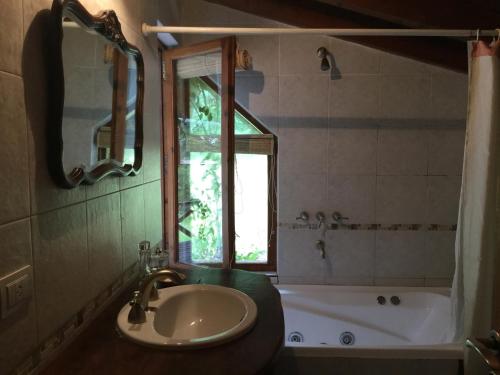 ein Badezimmer mit Waschbecken, Badewanne und Fenster in der Unterkunft Casa del Sur Villa La Angostura in Villa La Angostura