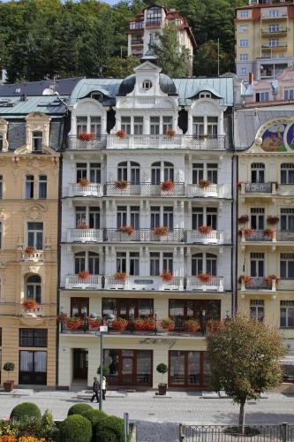 a large white building with flowers on the balconies at ASTORIA Hotel & Medical Spa in Karlovy Vary