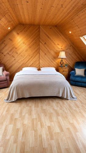 a bedroom with a bed and a wooden wall at Relaxing Loft Getaway Heart of County Meath in Enfield