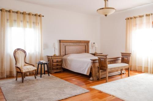 a bedroom with a bed and a desk and chairs at Quinta Vale do Armo in Sardoal