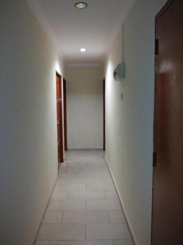 an empty hallway with a tile floor and a door at YY Residences in Ipoh