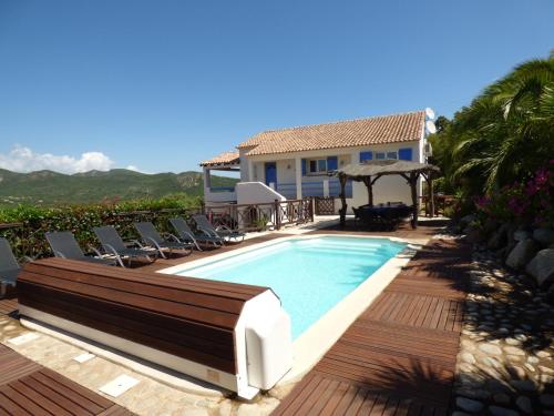 einen Pool mit Liegestühlen neben einem Haus in der Unterkunft Casa Di Cavalone in Sainte-Lucie de Porto-Vecchio