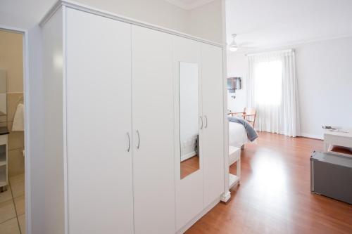 a large white cabinet in a bedroom with a bed at The Queen Of Calitzdorp in Calitzdorp