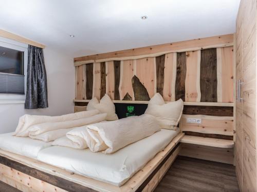 two beds in a room with wooden walls at Alpenapart Frank in Längenfeld