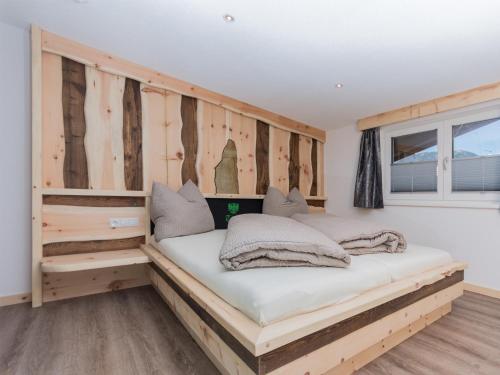 a bed in a room with wooden walls at Alpenapart Frank in Längenfeld