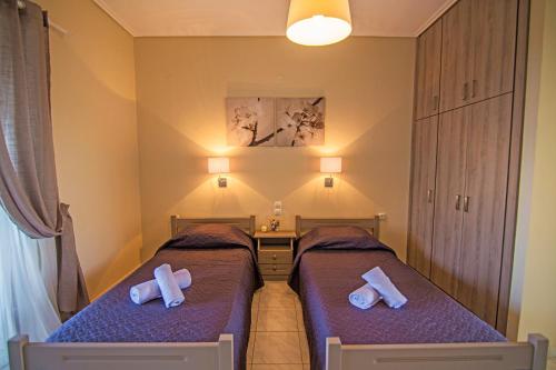 two beds in a small room with crosses on them at Kondarini's Sea View Studios in Tsilivi