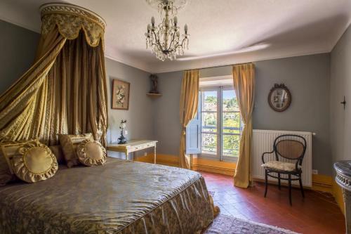 a bedroom with a bed and a chandelier at Château du Grand Jardin in Valensole
