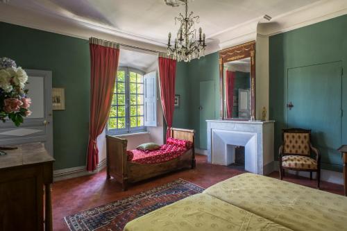 a bedroom with a bed and a fireplace and a chair at Château du Grand Jardin in Valensole