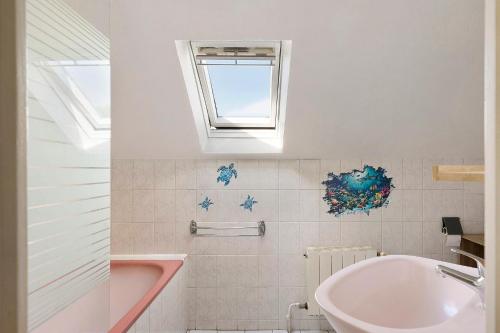 a bathroom with a sink and a tub and a window at La Ferme Des Bigornes in Châtillon-sur-Indre