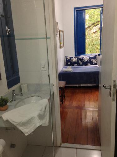 a bathroom with a tub and a sink and a window at Brasileranza Hostel in Niterói