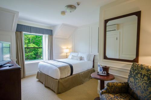 ein Hotelzimmer mit einem Bett und einem Spiegel in der Unterkunft Digby Pines Golf Resort and Spa in Digby