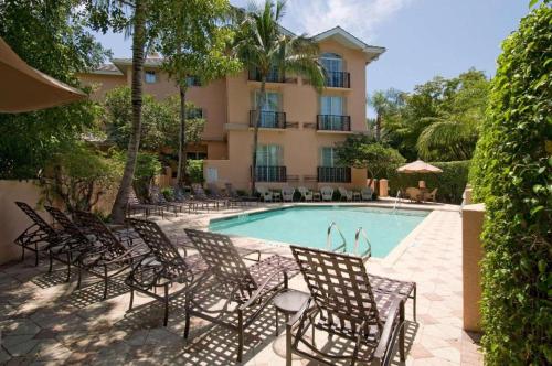 a group of chairs sitting around a swimming pool at The Capri Inn in Naples