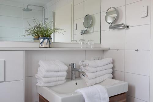 a white bathroom with a sink and a mirror at Strandhaus Christiansen in Cuxhaven