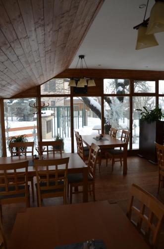 a dining room with tables and chairs and windows at Penzion Horal in Osek
