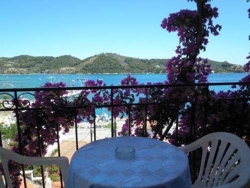 a table and chairs on a balcony with a view of the water at Babis in Skiathos Town