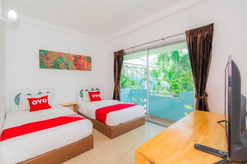 a bedroom with two beds and a tv and a window at Koh Lak Resort in Prachuap Khiri Khan