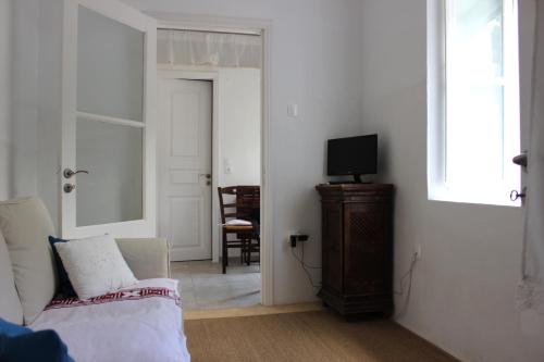 um quarto com uma cama, uma televisão e uma janela em Studio Annezo em Hidra