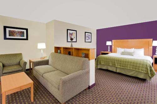 a hotel room with a bed and a couch at Ramada by Wyndham Marquette in Marquette