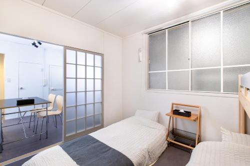 a bedroom with two beds and a desk and a table at Epilogue Hotel 202 in Fukuoka
