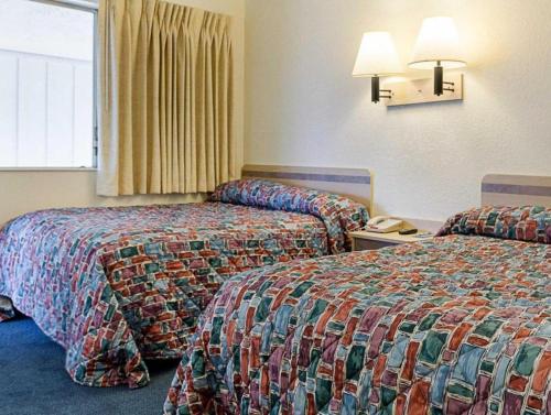 a hotel room with two beds and a phone at Loyalty Inn in Brice