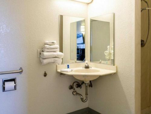 a bathroom with a sink and a mirror and towels at Loyalty Inn in Brice