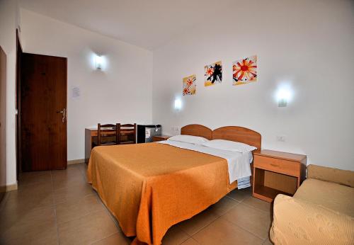 a bedroom with a large bed and a couch at Hotel Belvedere Lampedusa in Lampedusa
