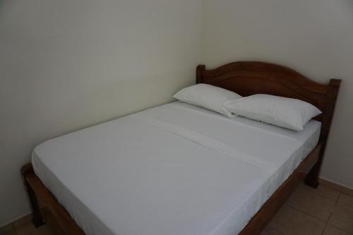 a bed with two pillows on it in a room at Villa Vilar in Coco