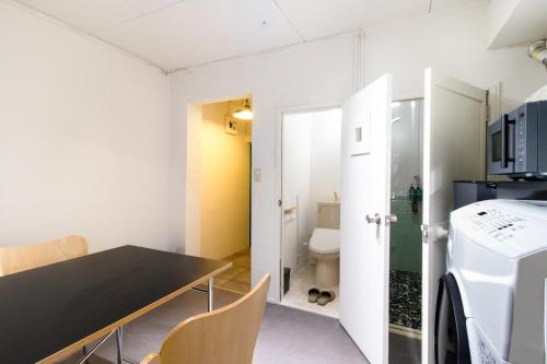 a small room with a table and a bathroom at Epilogue Hotel 202 in Fukuoka