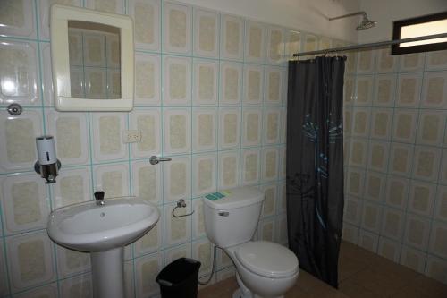 a bathroom with a toilet and a sink and a shower at Villa Vilar in Coco