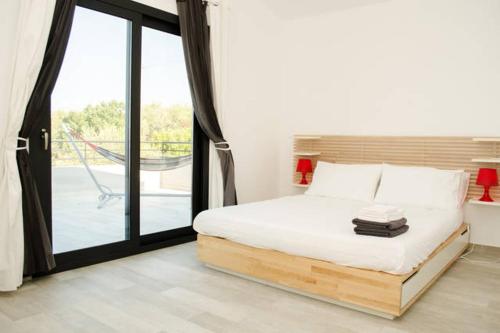 a bedroom with a bed and a sliding glass door at La Casa del Riccio in Tindari